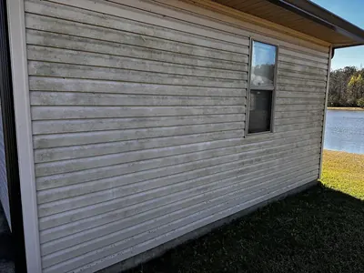 Dirty vinyl siding on a house before washing
